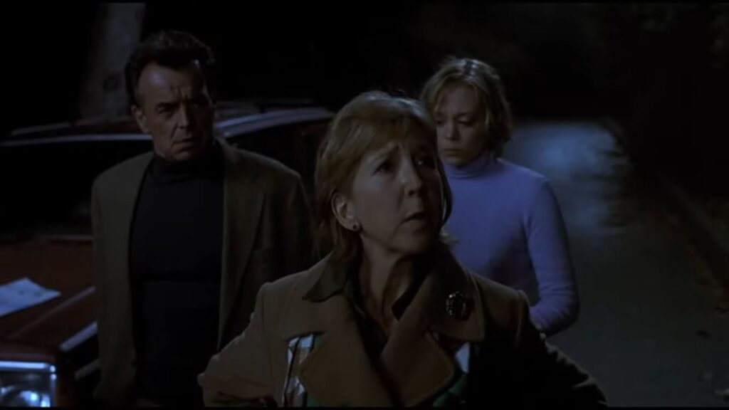 The Harrington family standing on a dark, tree-lined road at night in the psychological Christmas horror Dead End.