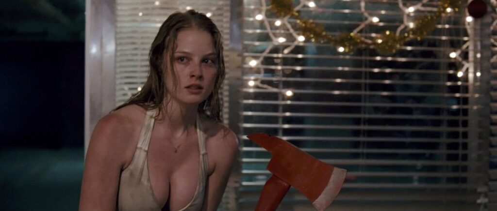Rachel Nichols wearing a low cut white dress and wielding an axe as she fights a security guard in the horror movie P2