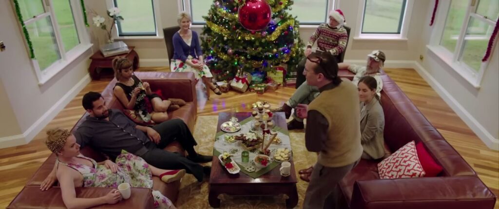 A high-angle shot of a family sitting on sofas around a Christmas tree during a tense argument in the Australian horror Red Christmas.