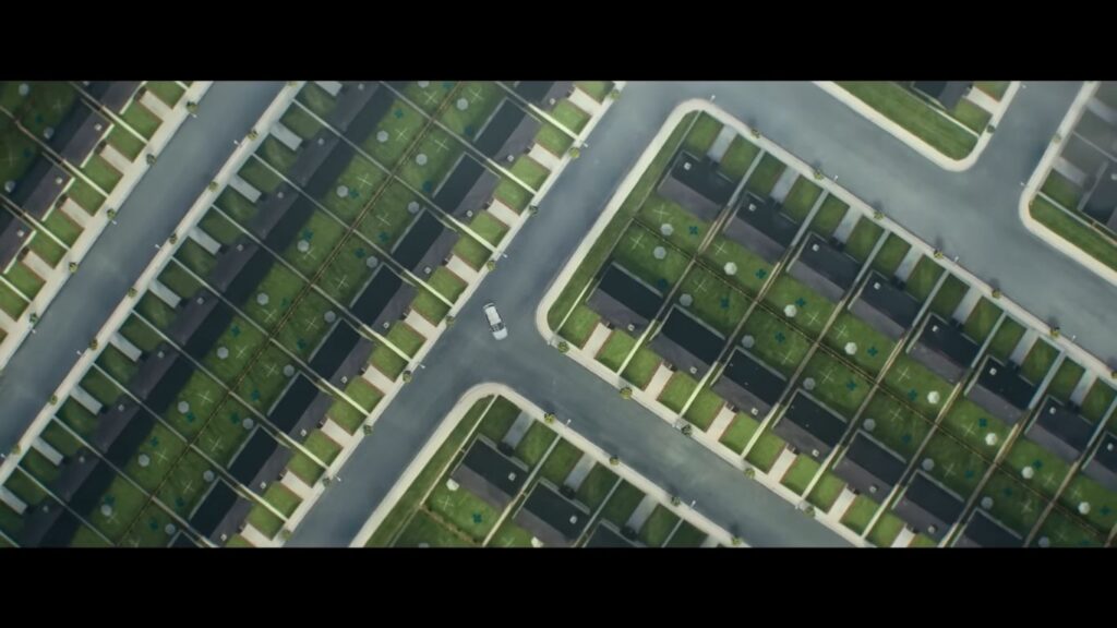 Vivarium (2019): An overhead view of a perfectly symmetrical, identical suburban housing development, showcasing an artificial and hostile liminal environment.