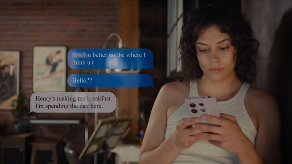 A woman in a grey tank top looking down at her smartphone with blue and white text message bubbles overlaid in Match.
